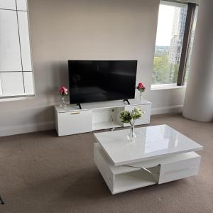 a white living room with a flat screen tv at Sydney Olympic Park 13Free Parking in Sydney