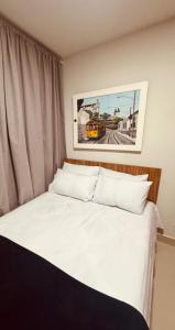 a bedroom with a white bed with a picture on the wall at Elohim Residencial in Rio de Janeiro +22 photos