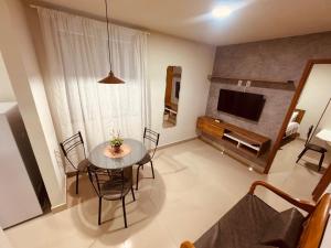 a living room with a dining table and a television at Elohim Residencial in Rio de Janeiro
