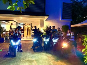 a group of people on motorcycles parked in front of a house at Goofy Ants Hostel in Puerto Princesa City
