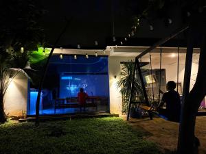 two people sitting outside of a house at night at Goofy Ants Hostel in Puerto Princesa City