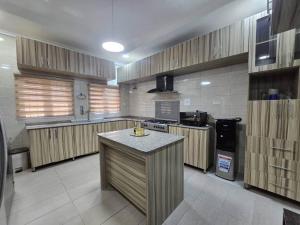 a large kitchen with wooden cabinets and a counter top at Pavilion Luxury 4bedroom duplex in Mama