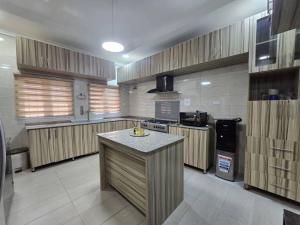 a large kitchen with wooden cabinets and a counter top at Pavilion Luxury 4bedroom duplex in Mama