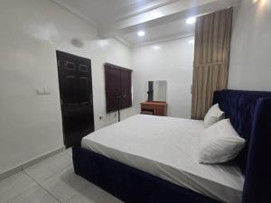a bedroom with a large bed with a blue headboard at Pavilion Luxury 4bedroom duplex in Mama