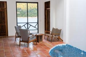 a room with chairs and a table and a window at Casa Azul, Oceanfront Estate with Rooftop Deck in Yelapa