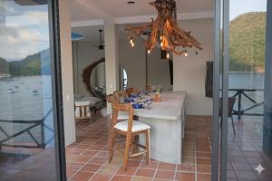 a dining room with a table and a view of the water at Casa Azul, Oceanfront Estate with Rooftop Deck in Yelapa +15 photos