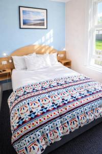 a bedroom with a bed with a colorful quilt on it at The Dannebrog Lodge in Devonport