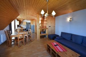 a living room with a blue couch and a table at Penzión Valaška in Starý Smokovec