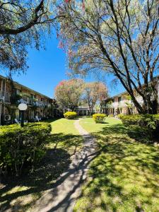 a walkway through a park with trees and buildings at The Select Inn Gosford in Gosford