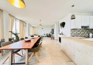 a kitchen and dining room with a long wooden table at Rheinpanorama Penthouse Neuss Düsseldorf in Neuss