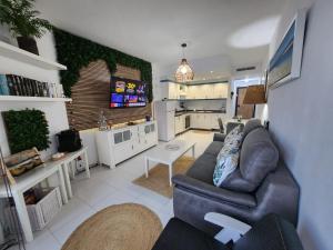 a living room with a couch and a tv at Ocean Luxury Apartment in Mogán