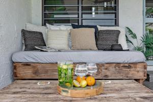 a bed with two wine glasses and fruit on a table at The Boho Casa - Beachside Retreat with Pool in Darwin