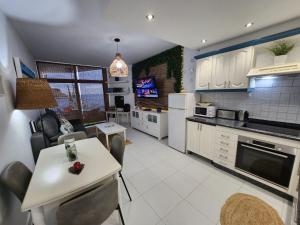 a kitchen and living room with a table and chairs at Ocean Luxury Apartment in Mogán +41 photos