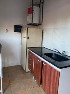 a kitchen with a sink and a refrigerator at Loft céntrico Maipú in Maipú