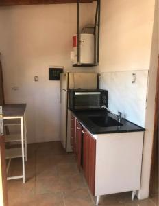 a small kitchen with a sink and a refrigerator at Loft céntrico Maipú in Maipú