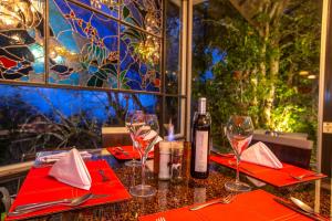 a table with two wine glasses and a bottle of wine at Dantica Cloud Forest Lodge in San Gerardo de Dota