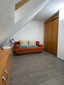 a couch sitting in a living room under a staircase at Apartament ALEX in Sibiu