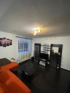 a living room with an orange couch and a table at Apartament ALEX in Sibiu