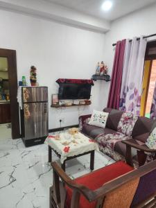 a living room with a couch and a tv at Villa kresilda in Gampola