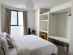 a bedroom with a white bed and a window at Casa 821 Guest House in Oaxaca City