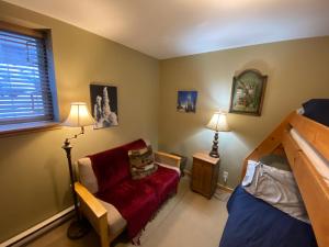 a bedroom with a red chair and a bed at Morrisey Chalet at Sun Peaks in Sun Peaks