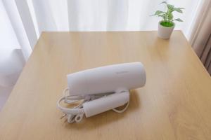 a white machine on a wooden table with a plant at Hotel Emile 101 in Tachikawa