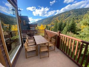 a table and chairs on a balcony with a view at Morrisey Chalet at Sun Peaks in Sun Peaks