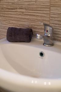 a brown towel sitting on top of a white sink at Hidden gem agora flat Checkpoint-Mytilene in Mytilene +8 photos