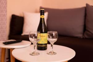 a bottle of wine and two wine glasses on a table at Hidden gem agora flat Checkpoint-Mytilene in Mytilene