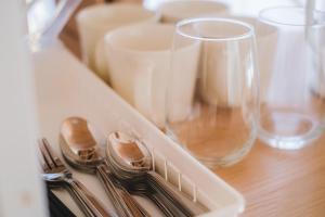 a table with forks and knives and wine glasses at Hotel Emile 101 in Tachikawa
