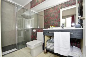 ein Badezimmer mit Toilette, Dusche und Waschbecken in der Unterkunft The Zentral Arenal Suites in Sevilla + 37 Fotos
