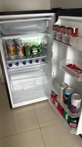 an open refrigerator filled with food and drinks at Hotel Serrinha in Botumirim