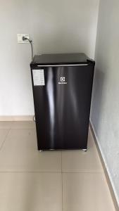 a black refrigerator sitting on the floor in a room at Hotel Serrinha in Botumirim