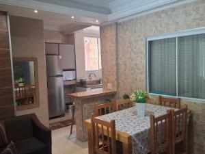 a kitchen and dining room with a table and chairs at Casa 2 Encanto dos Mares in Itapema
