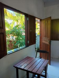 a wooden bench sitting in a room with a window at Villa Tropical Herbert in Itacaré