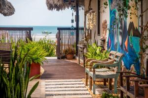 a wooden walkway leading to the beach with chairs at Espaço Fateixa in Jericoacoara