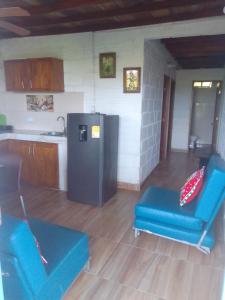 a kitchen with two blue chairs and a refrigerator at Apart Cabaña KTIK in San Bernardo del Viento