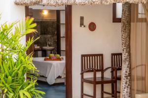 a room with a bed and a table and chairs at Espaço Fateixa in Jericoacoara