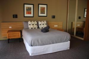 a bedroom with a large bed and a mirror at Nautilus Beach Apartment 109 in Coffs Harbour