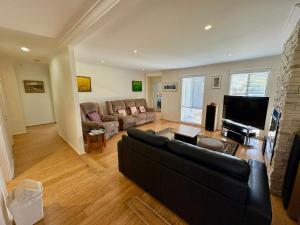 a living room with a couch and a television at Beachside Escape - Broadwater in Broadwater