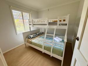 a bedroom with two bunk beds and a window at Beachside Escape - Broadwater in Broadwater