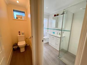 a bathroom with a toilet and a glass shower at Beachside Escape - Broadwater in Broadwater +21 photos
