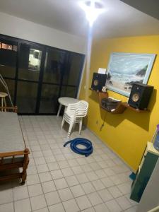 a room with a table and a chair and a screen at Apartamento com piscina e churrasqueira privativas in Cabedelo