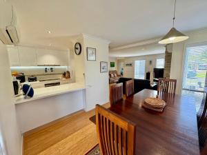 a kitchen and living room with a table and a dining room at Beachside Escape - Broadwater in Broadwater
