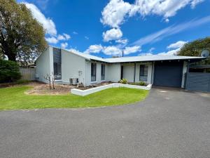 a white house with a driveway at Beachside Escape - Broadwater in Broadwater