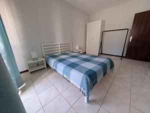 a bedroom with a bed with a blue checked blanket at Apartamento Espargos in Espargos