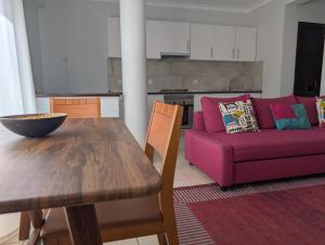 a living room with a table and a purple couch at Apartamento Espargos in Espargos