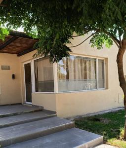 a house with steps leading up to the front door at Hospedaje Costanera del Sol in La Adela