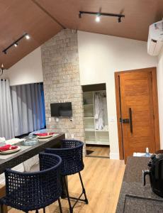 a living room with a table and chairs and a fireplace at Pousada Refúgio Pietra Blu in Domingos Martins