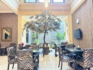 a restaurant with zebra chairs and tables and a tree at Pavotel Style Naz Hotel in Kamparganya